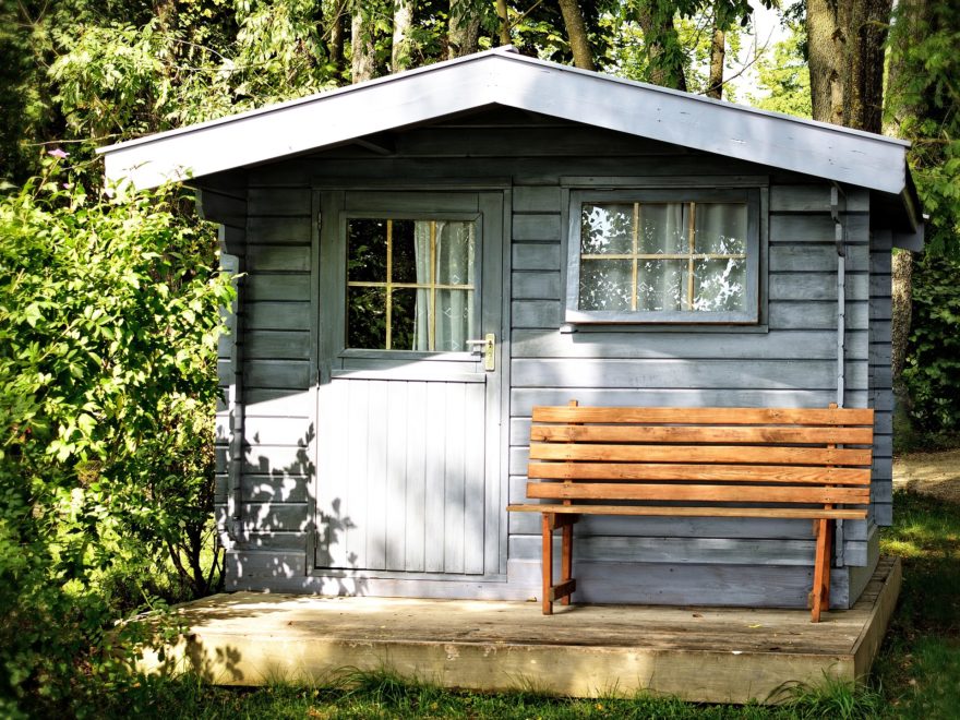 Holzhütte im Garten mit Bank