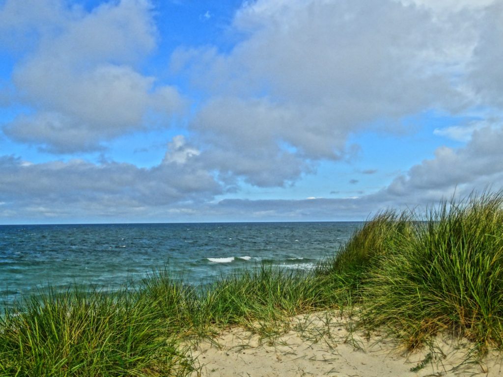 Strand mit Meer und Wolken am Horizont