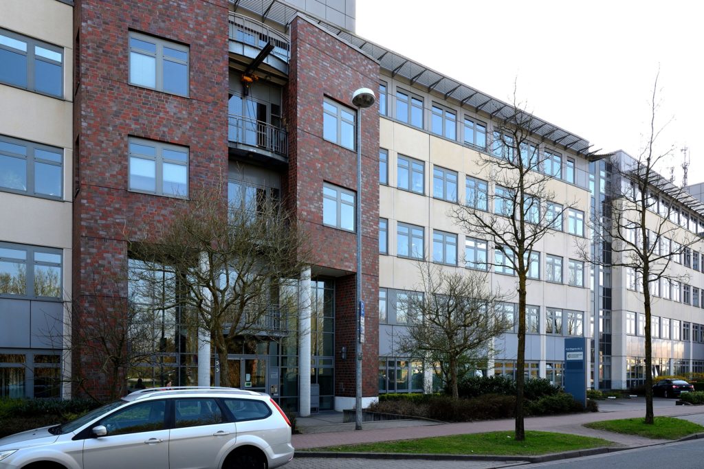 Gebraude mit modernen Büros und geparktem Auto.