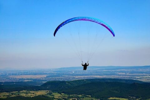 Paraglider über grüner Landschaft