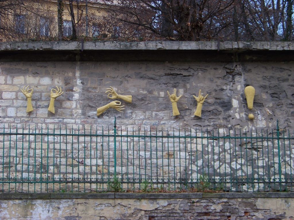 Reliefskulptur in Gebärdensprache an einer Steinmauer: „Das Leben ist schön, seid glücklich und liebt einander“, von der tschechischen Bildhauerin Zuzana Čížková in Prag